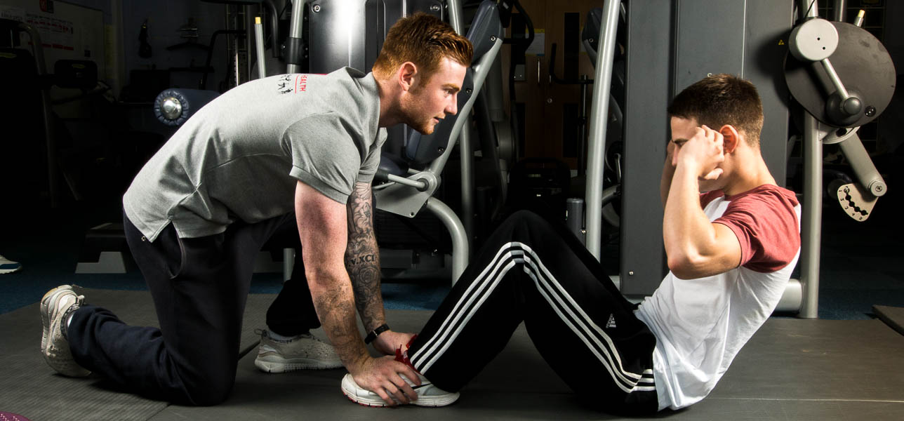 Luke assists with client sit-ups